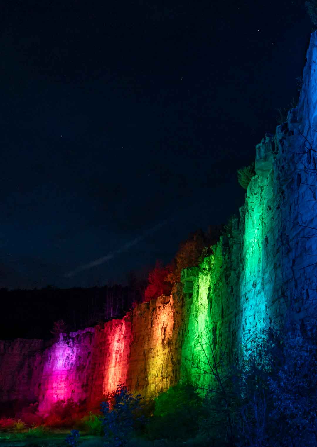 The quarry wall is illuminated with a light show after dark